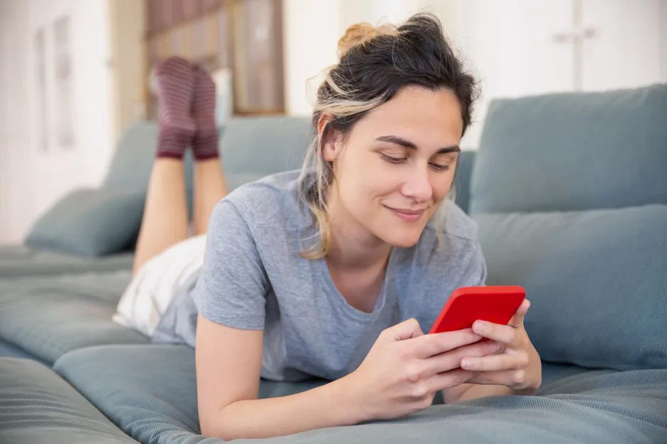 Frau nutzt entspannt ihr Smartphone - Auswahl der besten Atem-App im Vergleich