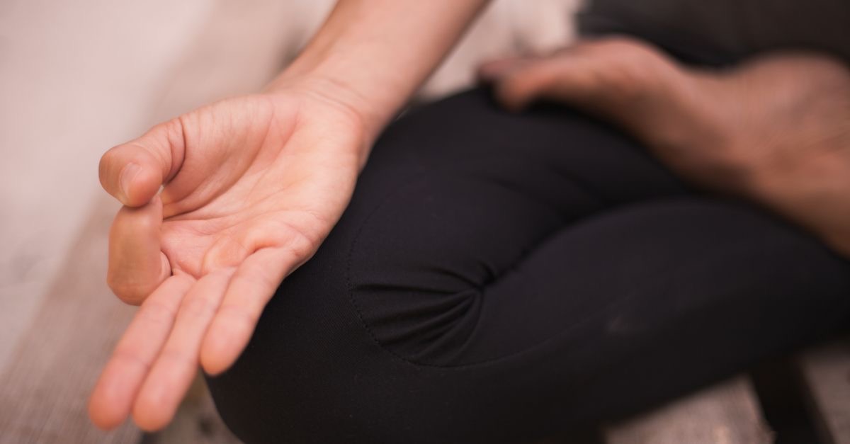 Nahaufnahme einer entspannten Handhaltung während einer sitzenden Meditation