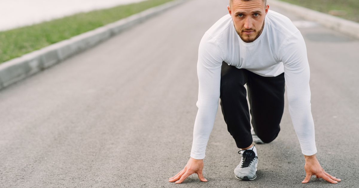 Mann in Sportkleidung bereitet sich konzentriert auf einen Lauf vor, Sinnbild für die körperliche Bereitschaft bei der Fight-or-Flight-Reaktion