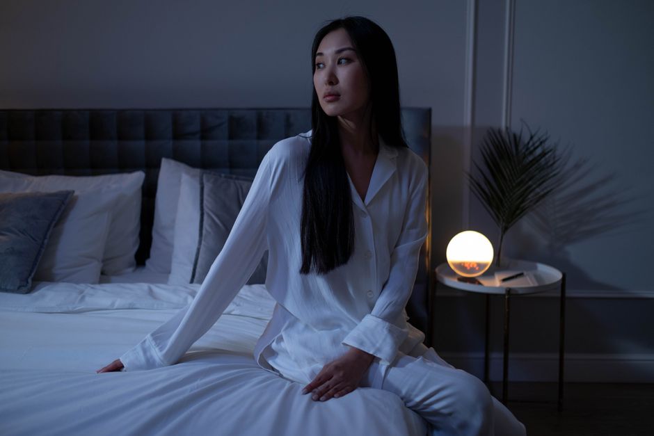Gedankenkarussell nachts stoppen Frau liegt abends wach im Bett - Gedankenkarussell stoppen und nachts zur Ruhe kommen