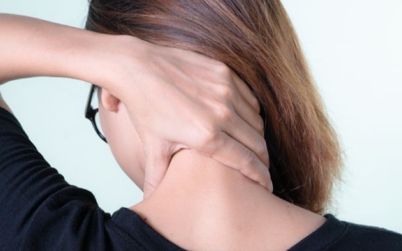 Frau massiert sich selbst den Nacken, Sinnbild für die Selbstmassage rund um den Vagusnerv