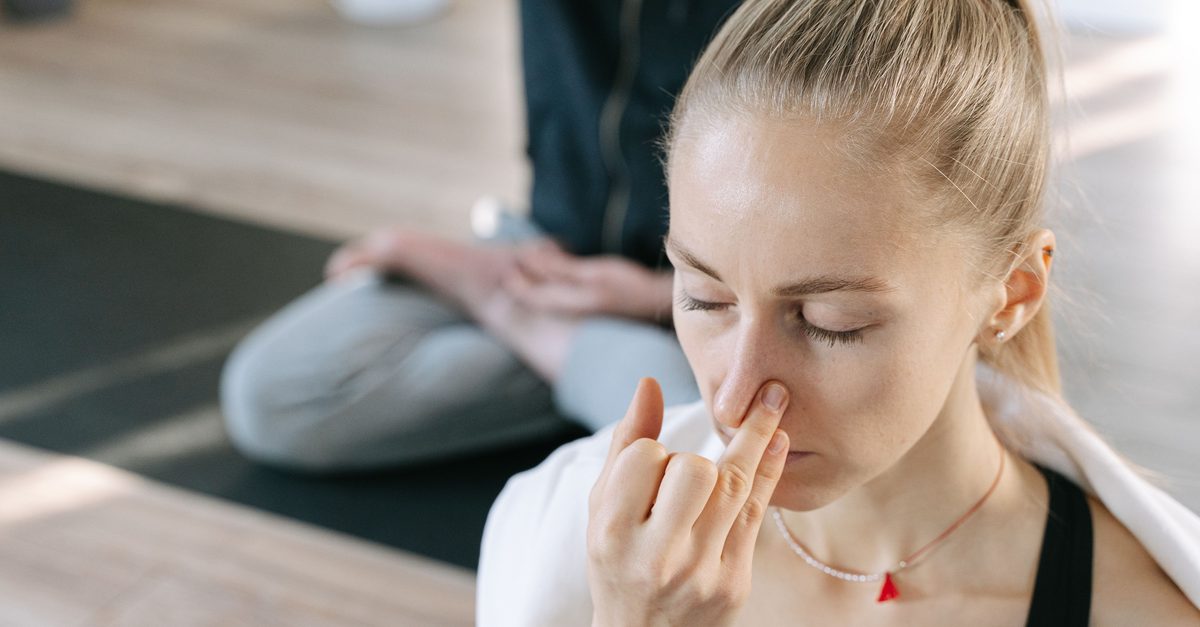 Wechselatmung: Vishnu Mudra Frau hält sich mit dem Daumen das rechte Nasenloch zu und übt die Wechselatmung